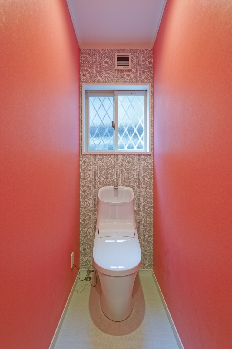 赤色の壁紙のトイレ