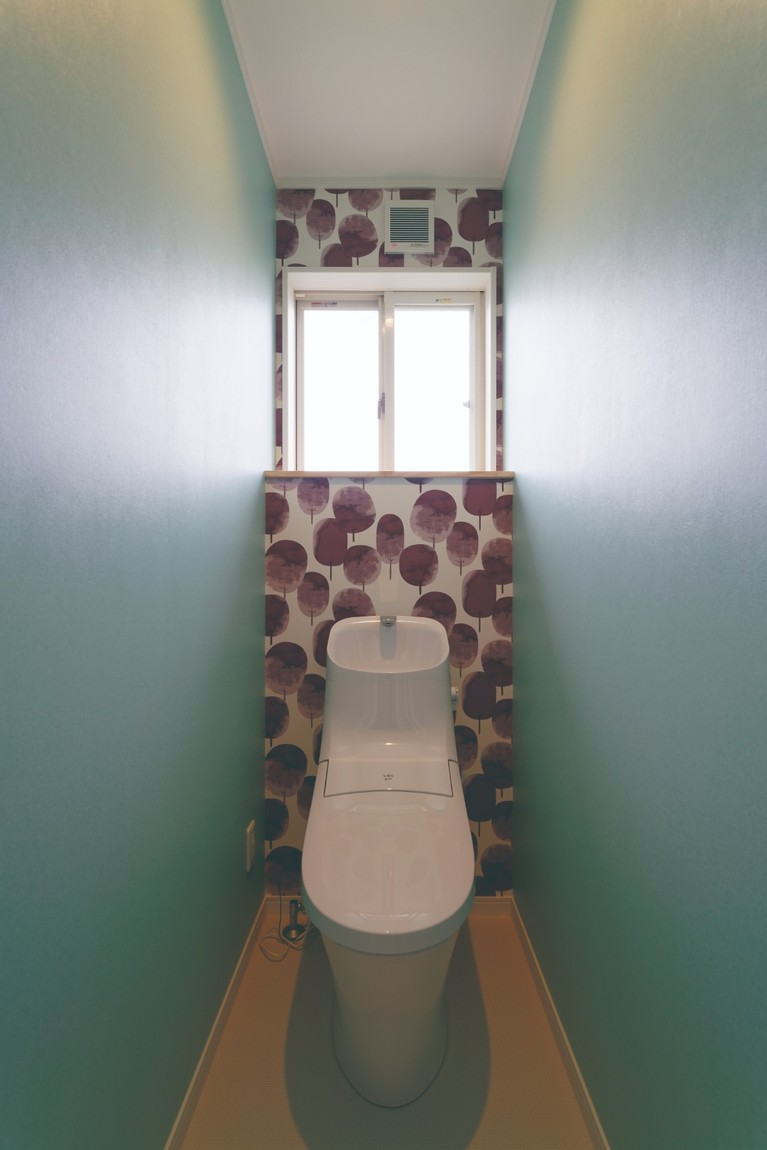 緑色の壁紙のトイレ